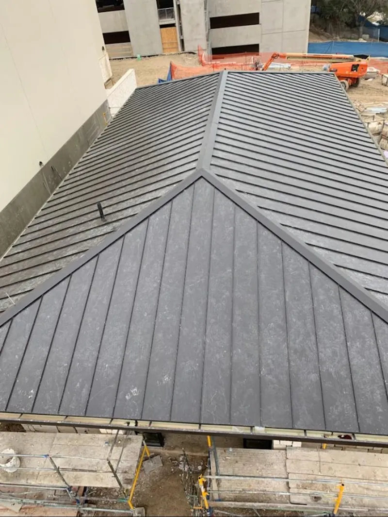 Commercial metal roof construction with crane equipment in Spring Hill